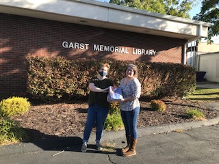 Two women holding the voters guide in front of the library in Marshfield.