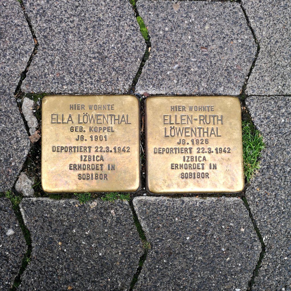 Dos placas de metal con inscripciones en la banqueta. Parte de las Stolpersteine, un proyecto de memoria y conmemoración a las víctimas del Holocausto