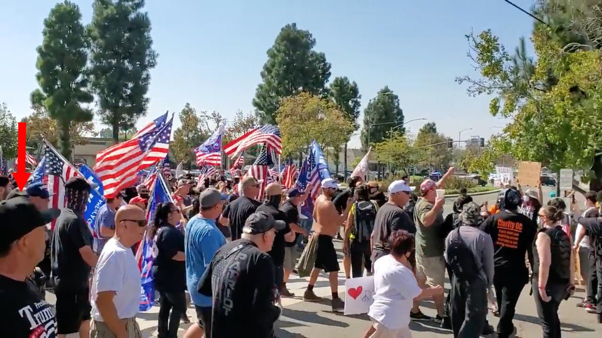 The target enters the screen from the left.The second member of the hit squad eyes him intently.Cast Lady identified him by texting and a photo.This is why Antifa takes your picture.