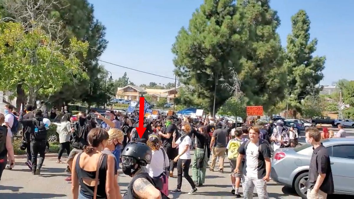 The target enters the screen from the left.The second member of the hit squad eyes him intently.Cast Lady identified him by texting and a photo.This is why Antifa takes your picture.