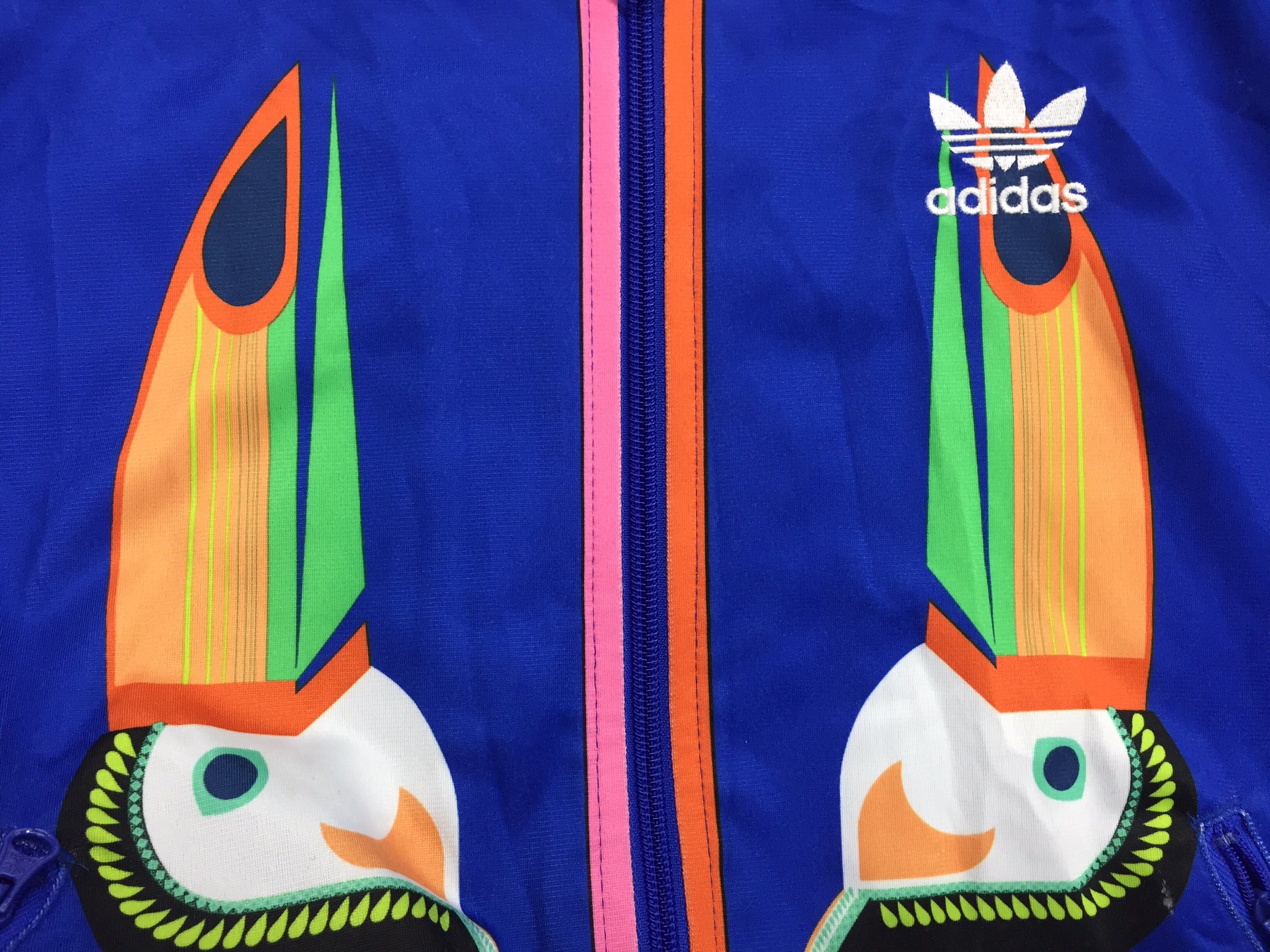 西海岸 行橋店 秋冬アイテム 続々入荷中 Adidasジャージ カラフルな鳥 と チャック部分の ピンクとオレンジのラインが可愛い 胸には刺繍 背中はプリントでのロゴが Adidasらしい感じです 古着屋西海岸 西海岸行橋店 スポーツブランド