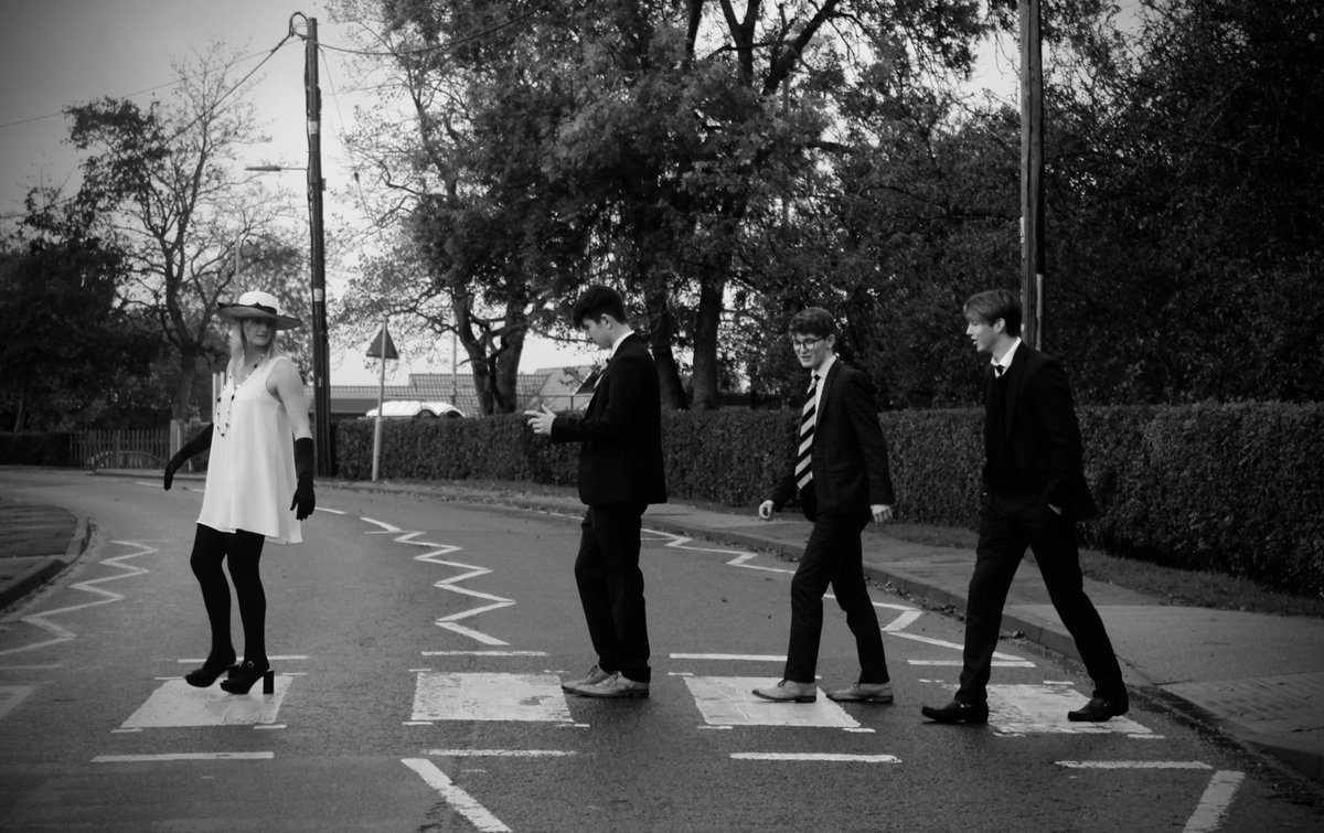 “Georgie might have come to school rather overdressed”. The boys seem unphased by her evening wear on a rainy afternoon. Photo by Cat C, year 13. Thank you to Georgie &amp; “the boys” for helping with this shoot inspired by William Klein &amp; “the” Abbey Road pic.