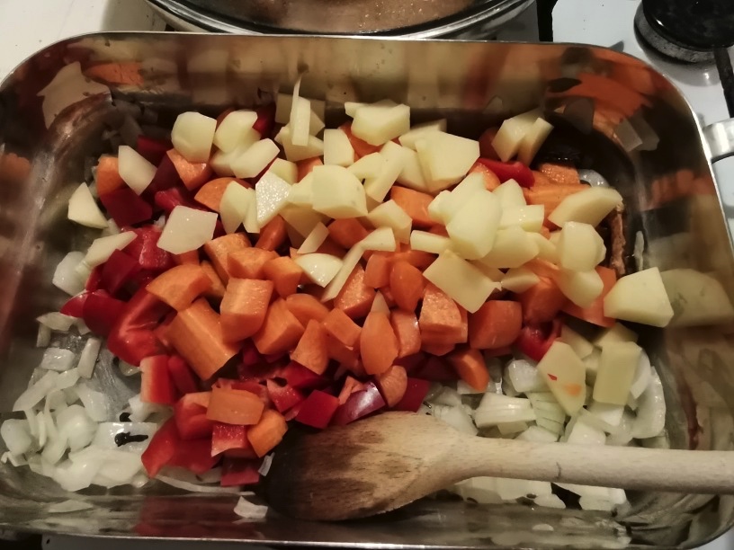 Dice the potatoes, red pepper and carrot and add it to the sautéd onions. Sauté for another minute or two.