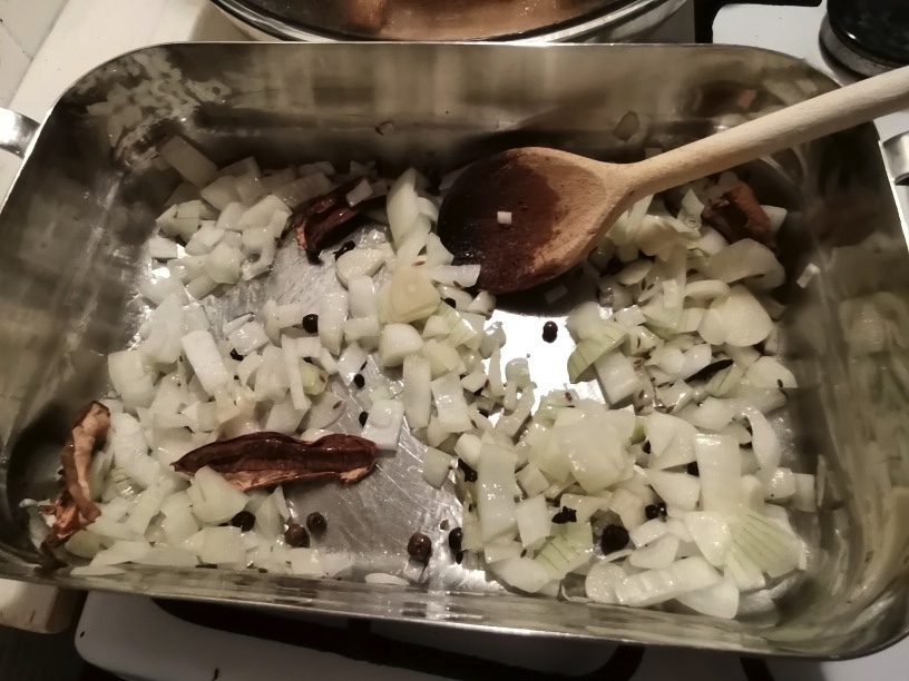 Dice the onion and the garlic, and sauté it together with the spices and the dried wild mushrooms, in a skillet which has a lid ( you will need the lid late to practically "steam" the fish), until the onions are tender and the spices had time to develop some flavour.