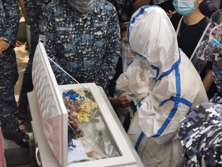 LOOK: Nasino, cuffed, wearing a full PPE set, and flanked by cops, gazes at her daughter River for the final time at the Manila North Cemetery. (: Kapatid) |  @MBMinkaTiangco