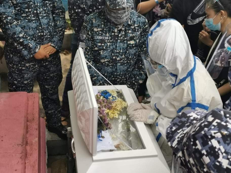 LOOK: Nasino, cuffed, wearing a full PPE set, and flanked by cops, gazes at her daughter River for the final time at the Manila North Cemetery. (: Kapatid) |  @MBMinkaTiangco