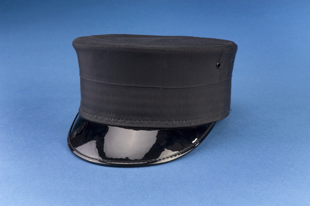 A little about that hat, similar traditional conductor cap is black with stiff crown, flat circular top, short visor & looks reminiscent of a French kepi. These styles of hats were typically worn by train conductors, brakemen & stationmasters in the 19th & early 20th century.