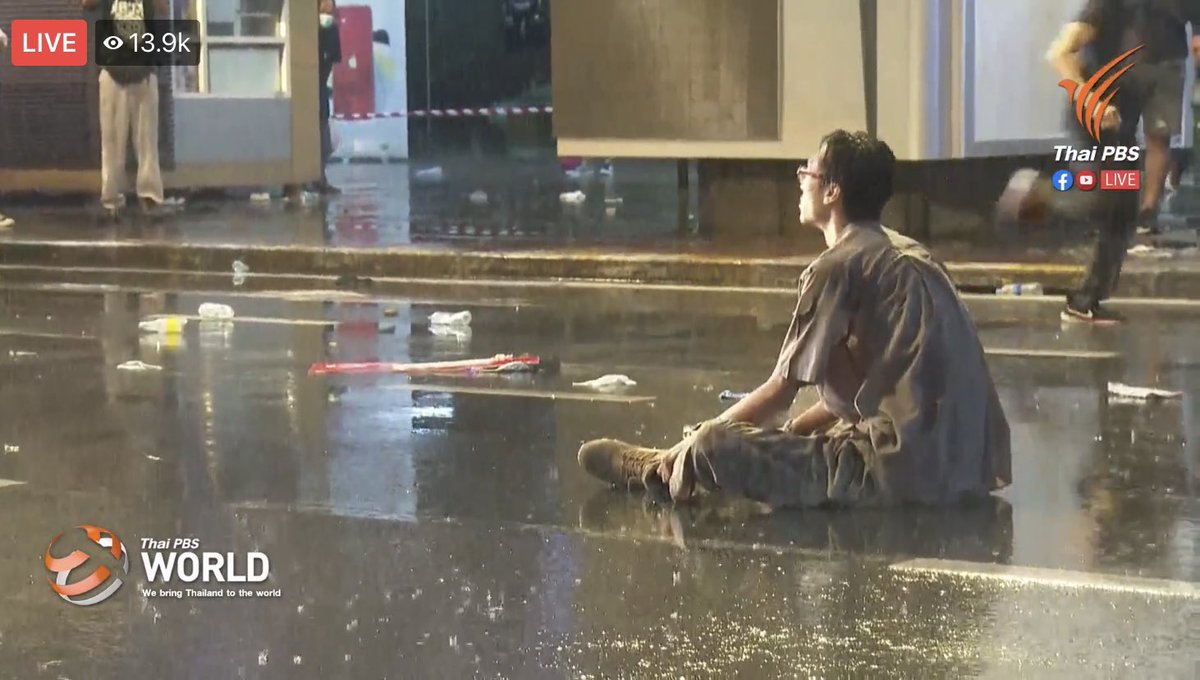 emesspace's tweet photo. Breaking‼️ This brave man was arrested by the police, but what he did was harmless.

1. Stayed on the road to prevent police vehicles to move forward, protecting thousands of people behind.
2. Handed the white bow to the police.

Please spread this! 

#whatshappeninginthailand https://t.co/DwhXnYq5H5