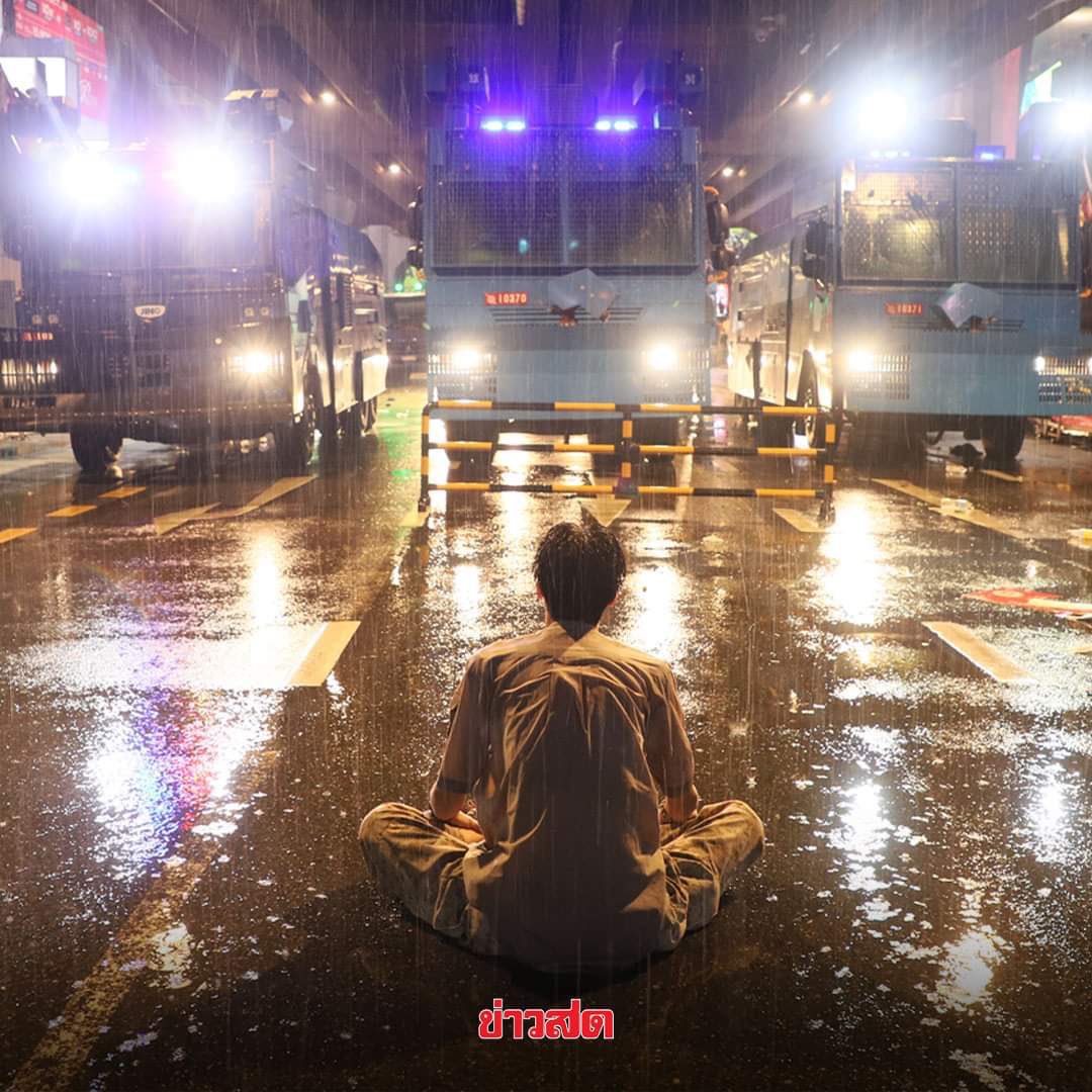 emesspace's tweet photo. Breaking‼️ This brave man was arrested by the police, but what he did was harmless.

1. Stayed on the road to prevent police vehicles to move forward, protecting thousands of people behind.
2. Handed the white bow to the police.

Please spread this! 

#whatshappeninginthailand https://t.co/DwhXnYq5H5