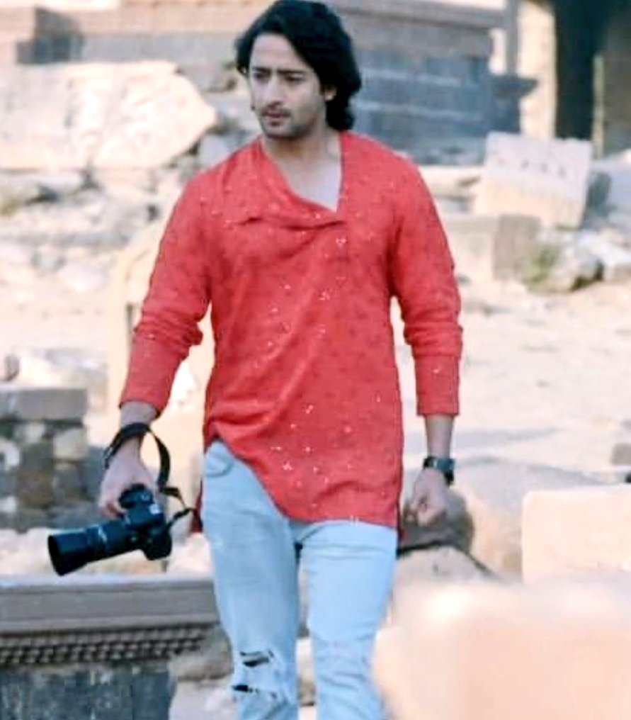 Stylish AbirThe red kurta with the neckline suits the flowy hairs of Abir those rolled up sleeves with his signature camera in his hand is just making him look adorable Adding to the spice is those ripped jeans making the look more Abirilious #EvergreenShaheerAsAbir