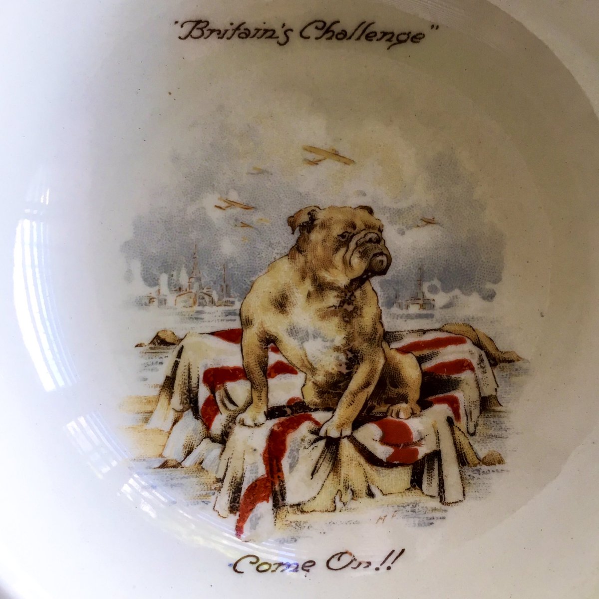 Zooming in to learn more about my new hobby of wartime themed babies’ crockey, it’s become apparent that there is a slight difference between the two plates. When a Union Jack is not enough for our intrepid bulldog, simply swap it for what appears to be Saint George’s Cross.