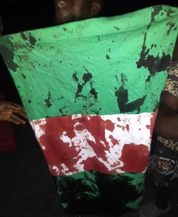 vanguardngrnews's tweet photo. On this day 20-10-20, the Nigerian flag was stained with the blood of the innocent #EndPoliceBrutalityinNigera protesters. https://t.co/aXTwrYkn21