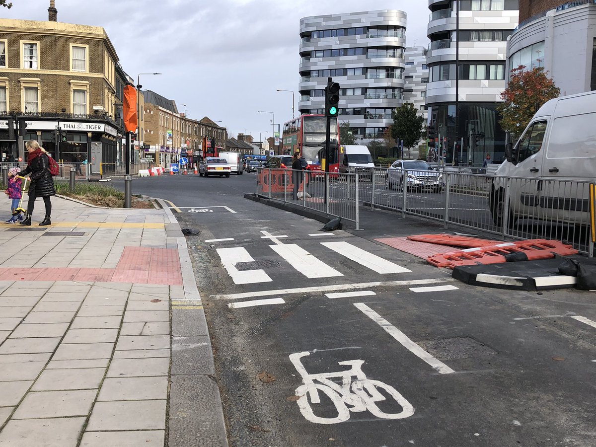 You then approach the busy Blackwall Lane junction. There’s a traffic light controlled filter lane for bikes but not yet operational. At least someone’s been down there and reinstated the temp barriers (pic left: last week, pic right: today)