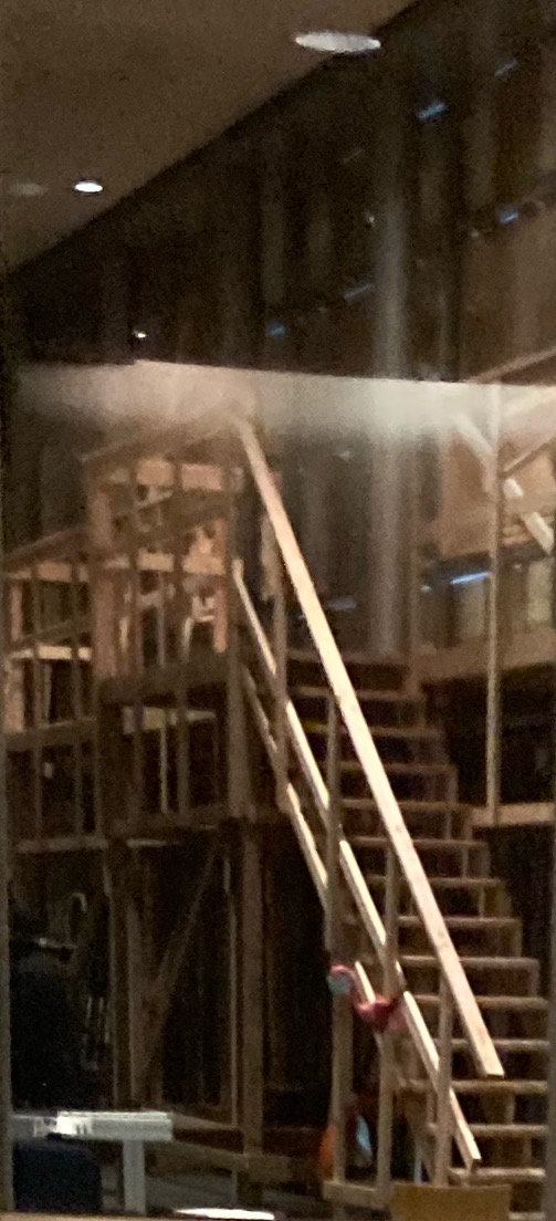 Wooden scaffolding. A wooden staircase leads to catwalks of various heights. At least 2 stories or scaffolding here