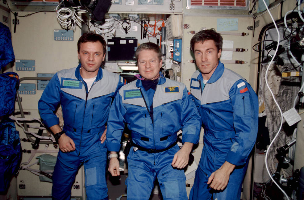 Expedition 1 crew of three poses for group photo inside International Space Station