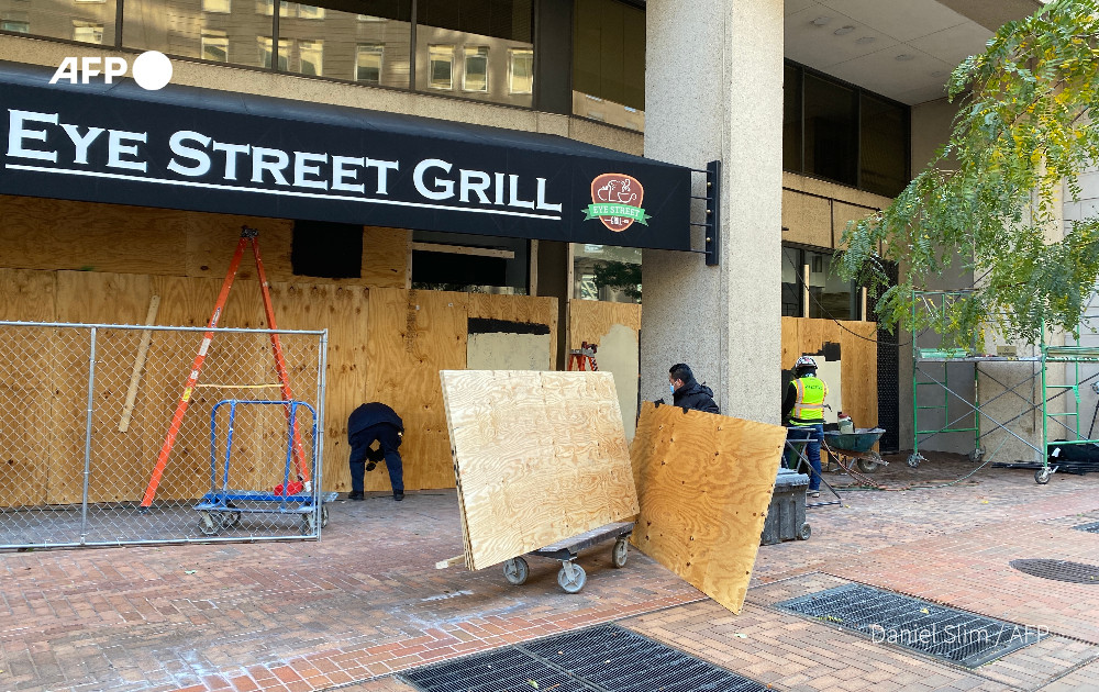 Workers in New York, Washington DC and Los Angeles board up businesses to protect them from potential civil unrest during the US presidential race  Timothy A. Clary, Daniel Slim, Frederic J. Brown