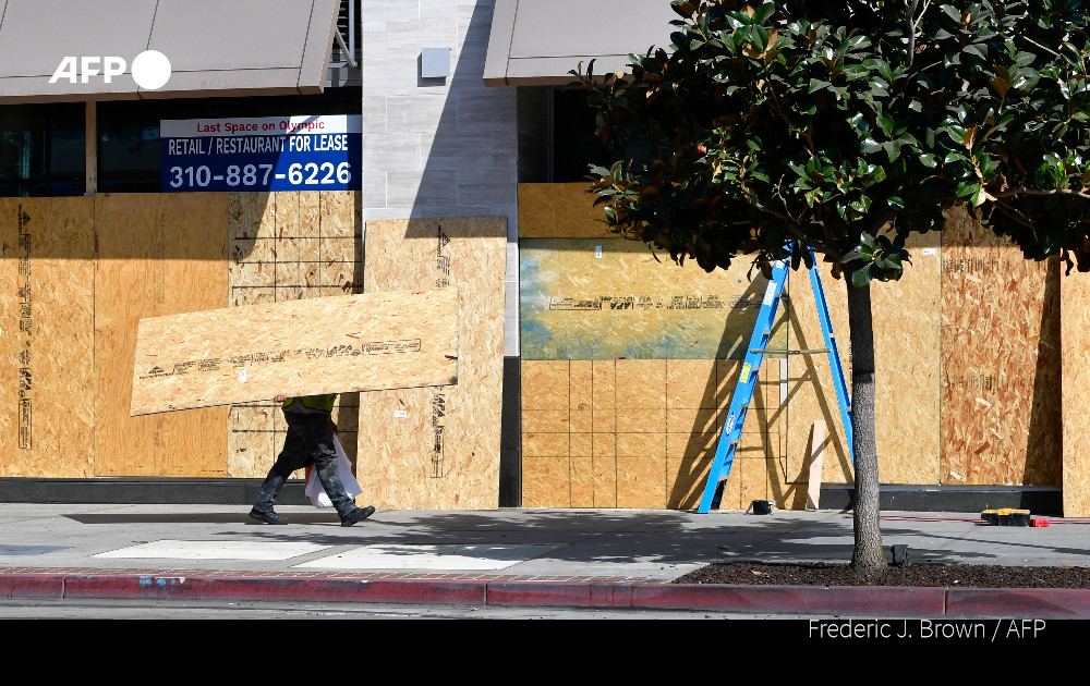 Workers in New York, Washington DC and Los Angeles board up businesses to protect them from potential civil unrest during the US presidential race  Timothy A. Clary, Daniel Slim, Frederic J. Brown
