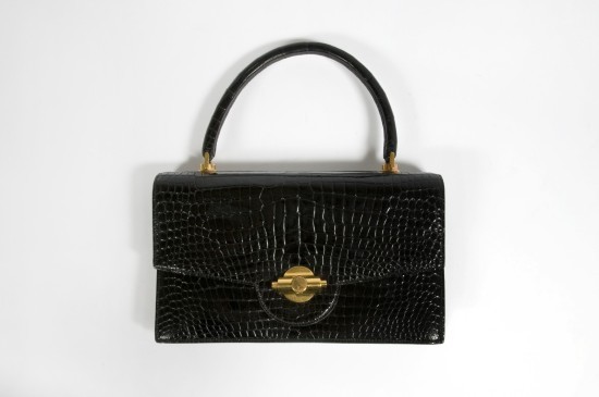 Il faudra attendre 1930 pour qu’Hermès réduise la taille du Torpedo et créée la première version du Kelly. Il sera revisité en 1935 avec le changement de la coupe, l’utilisation d’un cuir rigide et l’utilisation d’un fermoir équipé d’un cadenas.