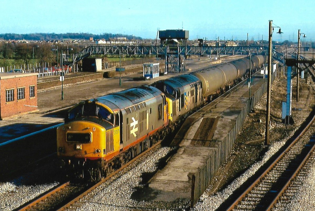 In contrasting styles of Railfreight liveries, British Rail Class 37 pairing 37371 & 37274 storm through Severn Tunnel Junction station with a train of 100 Ton Bogie Oil Tank wagons 29/4/91 #Railfreight #Class37 #BritishRail #SevernTunnel #trainspotting #diesels 🤓