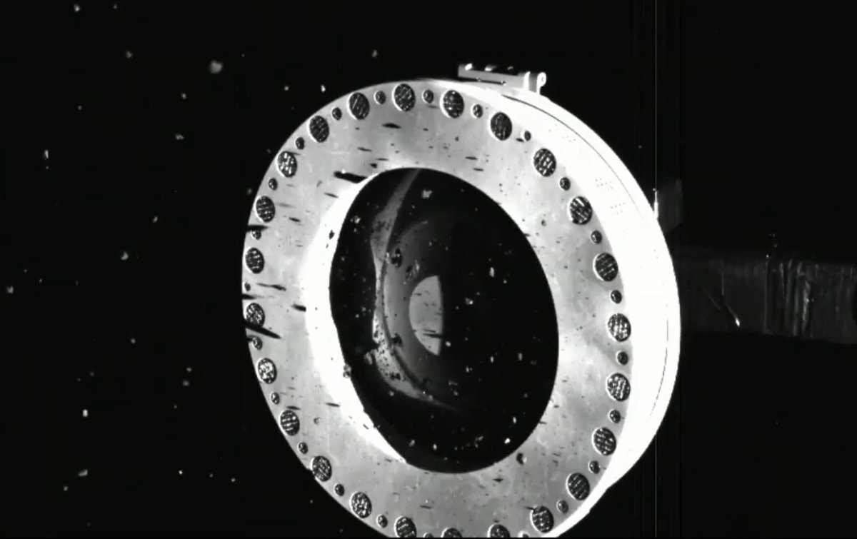 OSIRIS-REx collected regolith, but some large particles are jamming the diaphragm open (screen capture from NASA press event); the black horizontal streaks are shadows of large particles...