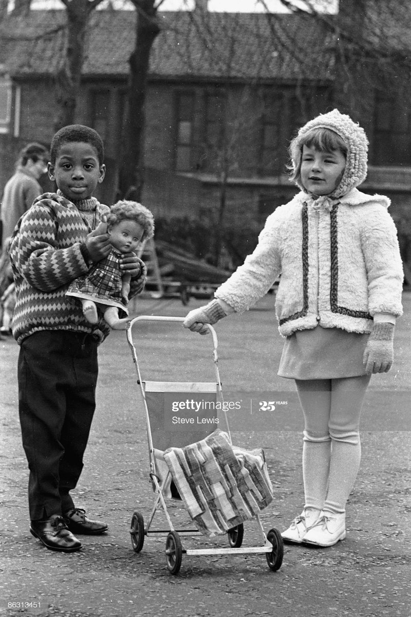 No one is born racist .Two kids playing with a doll in the East End of London, 1960s. Photo by Steve Lewis