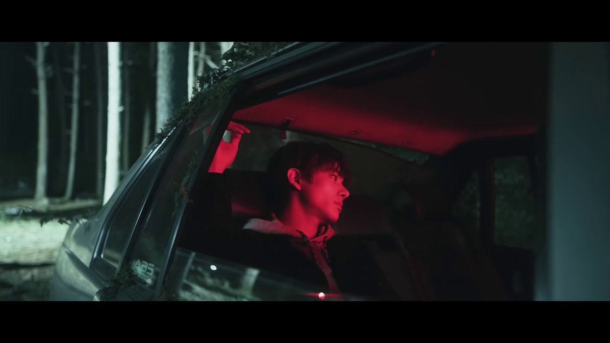 immediately after, there's a beat that 'hits', and as if he is the answer to the tense music until now, we see jake. he's in a car, awashed in ominous red light, and seems- until now- to be the only member we've seen who doesn't look emotionally scarred or terrifed.