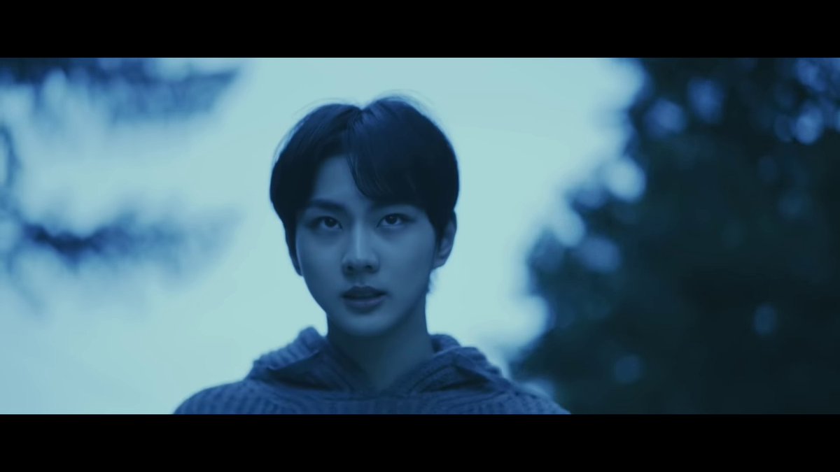 the screen fades to black & the music stops. like i said, the previous shot was a resolution, and ending. now, the color palette has compeltely shifted from dark greens to cold hues of blue. jungwon walks resolutely towards the rest of them, like a decision has been made,
