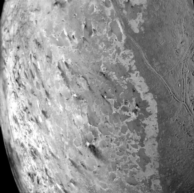 Neptune's icy moon Triton and saw an icy plume rising 8 kilometers above the surface! This is a picture of Triton's South Pole, the dark spots could potentially be the eruptions of many ice volcanoes [Credit: NASA/JPL].(13)