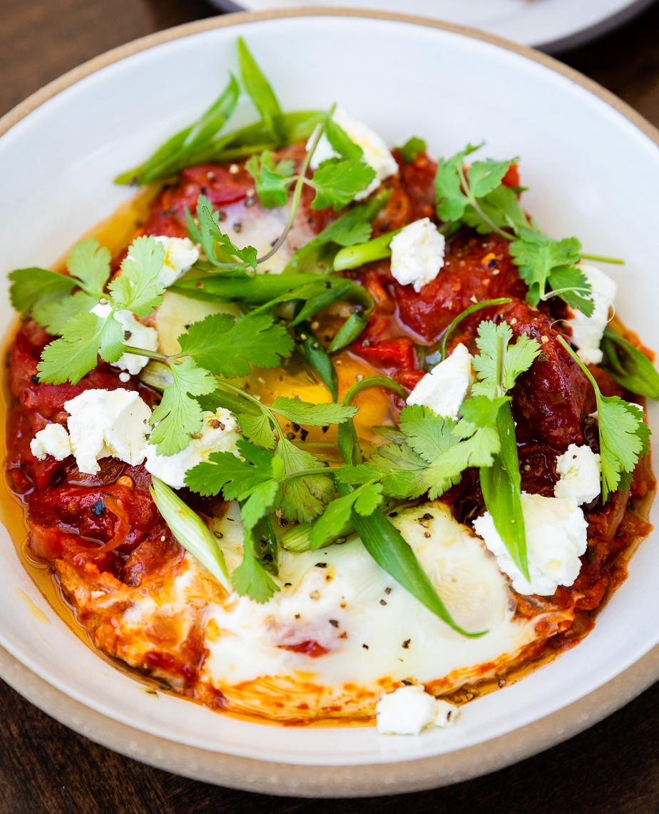 Anyone else wanna go swimming in these stewed tomatoes 🍅🏊🤿? 

Featuring our Shakshuka with stewed tomatoes and peppers, baked eggs, goat cheese, and cilantro served with house-made country bread⁠