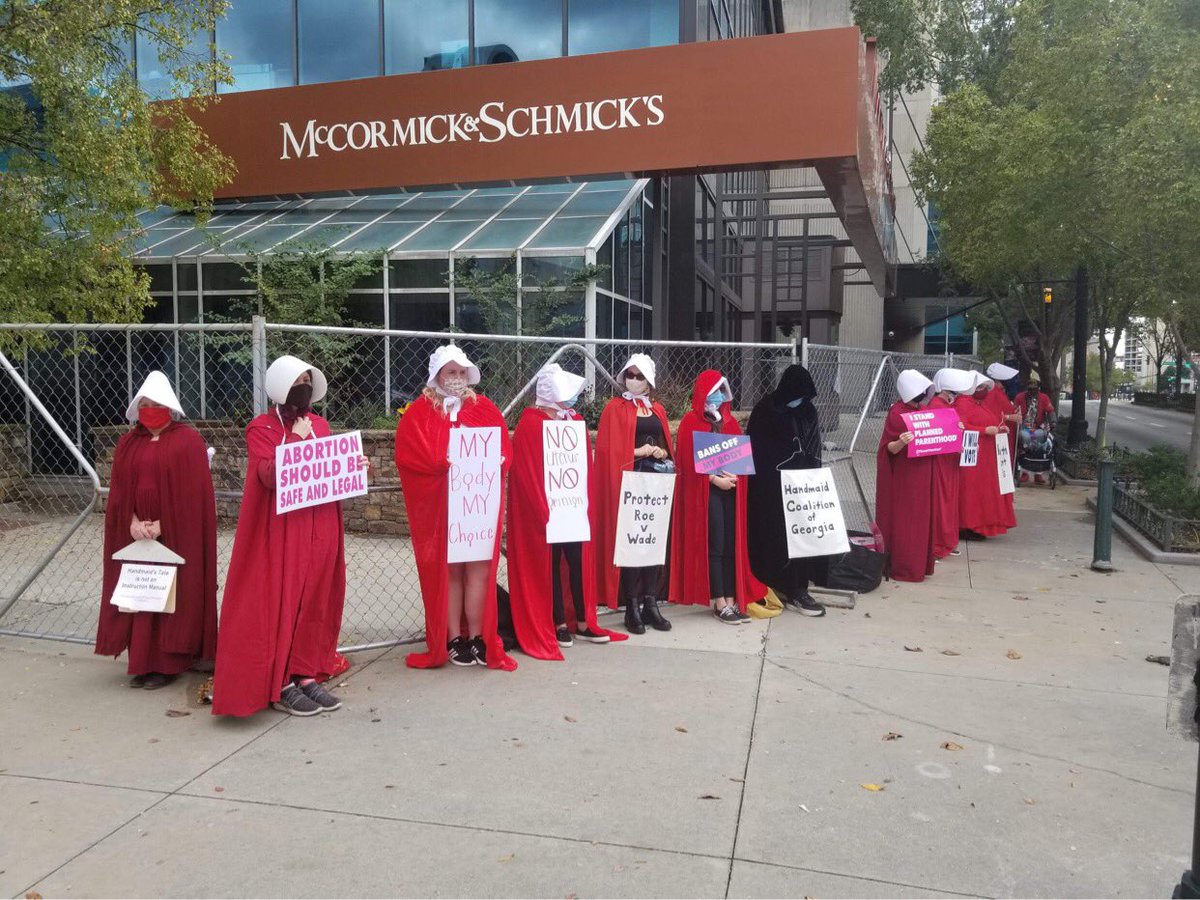 HandmaidsGA's tweet photo. Magic is happening just in front of McCormick and Schmidt, by the State Farm Arena. We silently protest for voting integrity, voting rights, which translate to reproductive justice in the US. #RuthSentUs #PissedOffPeaches #HandmaidCoalition #RedCloakProtest https://t.co/Uaej5kTcf1