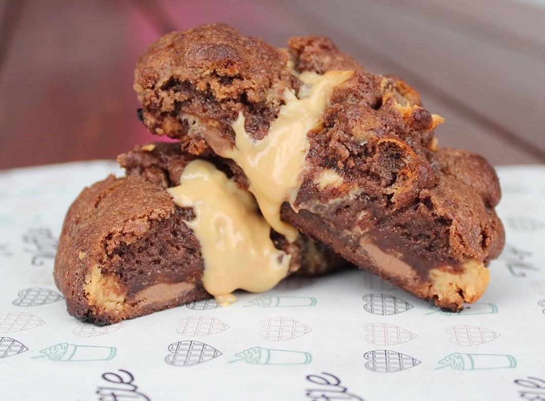 A chocolate peanut butter stuffed cookie cut in half by Oh My, Waffle.