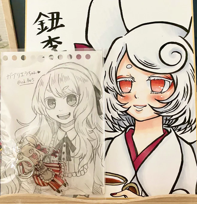 椎焚さん(@ssk_the5 )のプレゼント企画当選したので鈕李ちゃんグッズいただきましたー!色紙やガブリエラまで…ありがとうございます…飾って癒されます🙏✨ 