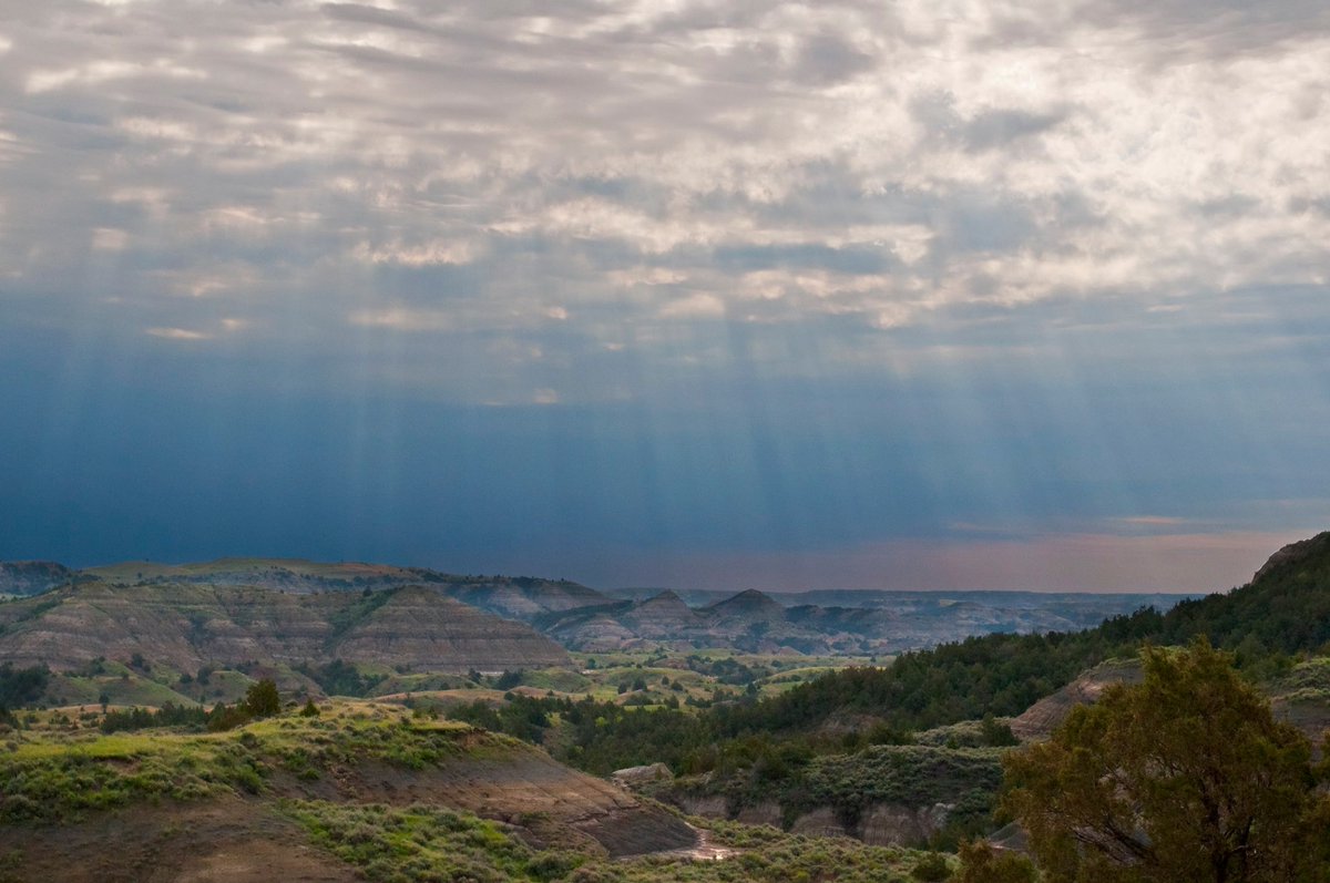 sunbeams pour from the sky over Theodore Roosevelt National Park in North Dakota