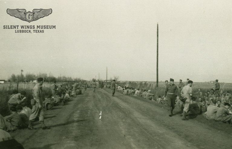 South Plains Army Flying School student glider pilots take a rest on their 16-mile march to Buffalo Springs Lake in 1942. The man taking the photo made sure to note on the back that it was “Rough as Hell.”