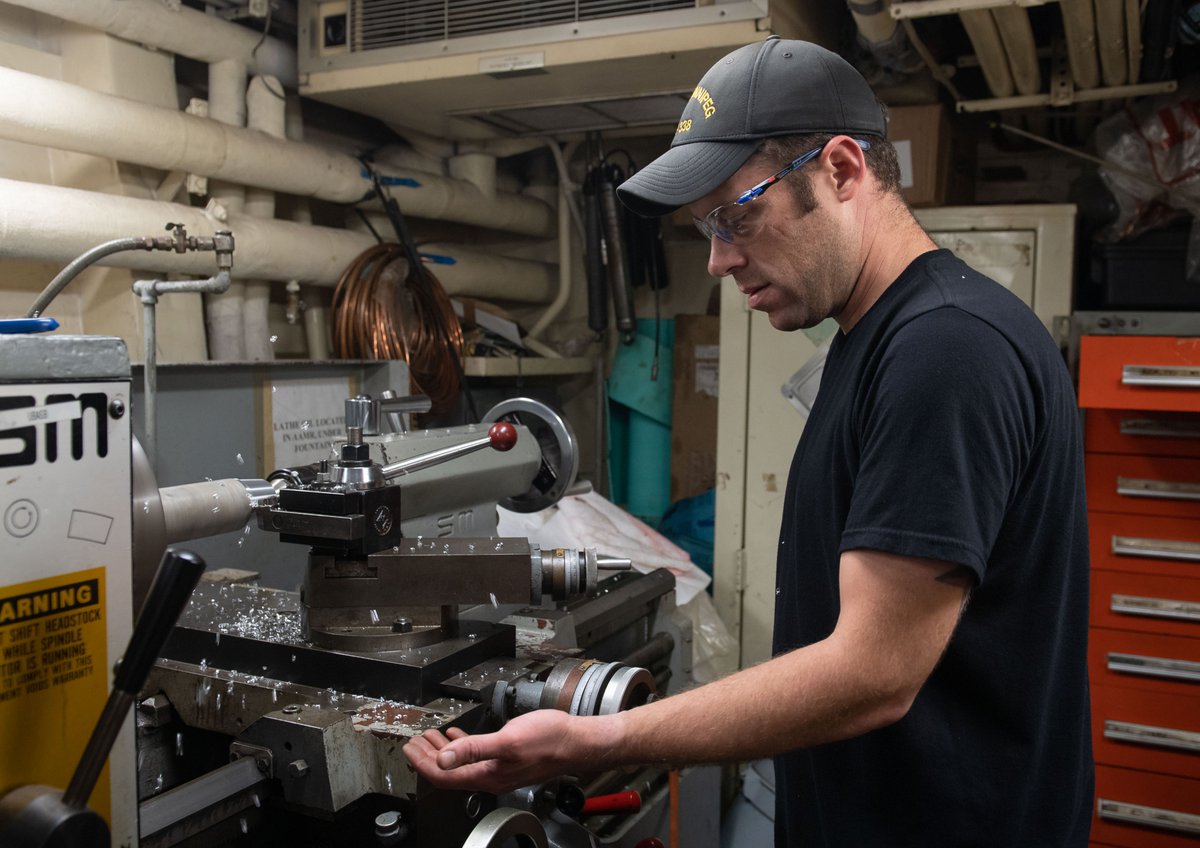 Petty Officer 2nd Class Nick Barrett operates the lathe on board Her Majesty's Canadian Ship (HMCS) WINNIPEG during OP PROJECTION-NEON on 25 October 2020. Having observed a quarantine period prior to deployment, members on board HMCS Winnipeg do not wear masks in the normal course of their duties unless they are interacting with members of the public during port visits (e.g. storing ship, embarking a pilot, etc.).Photo: Sailor 1st Class Valerie LeClair, MARPAC Imaging Services