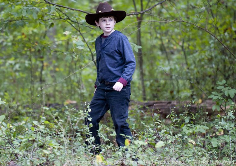 Chandler Riggs as Carl GrimesThe child soldier. The kid. Robbed of his youth, but determined to make sure the next generation thrives. Flirted with darkness, but filled with light. A son & a brother. Forced to carry the weight of the world on his shouldersThis is Carl Grimes.