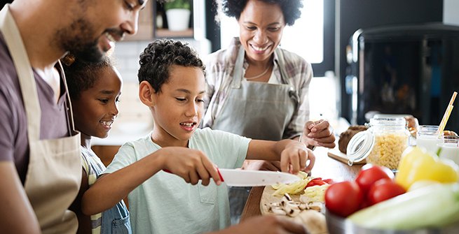 a family of four cooking a meal together