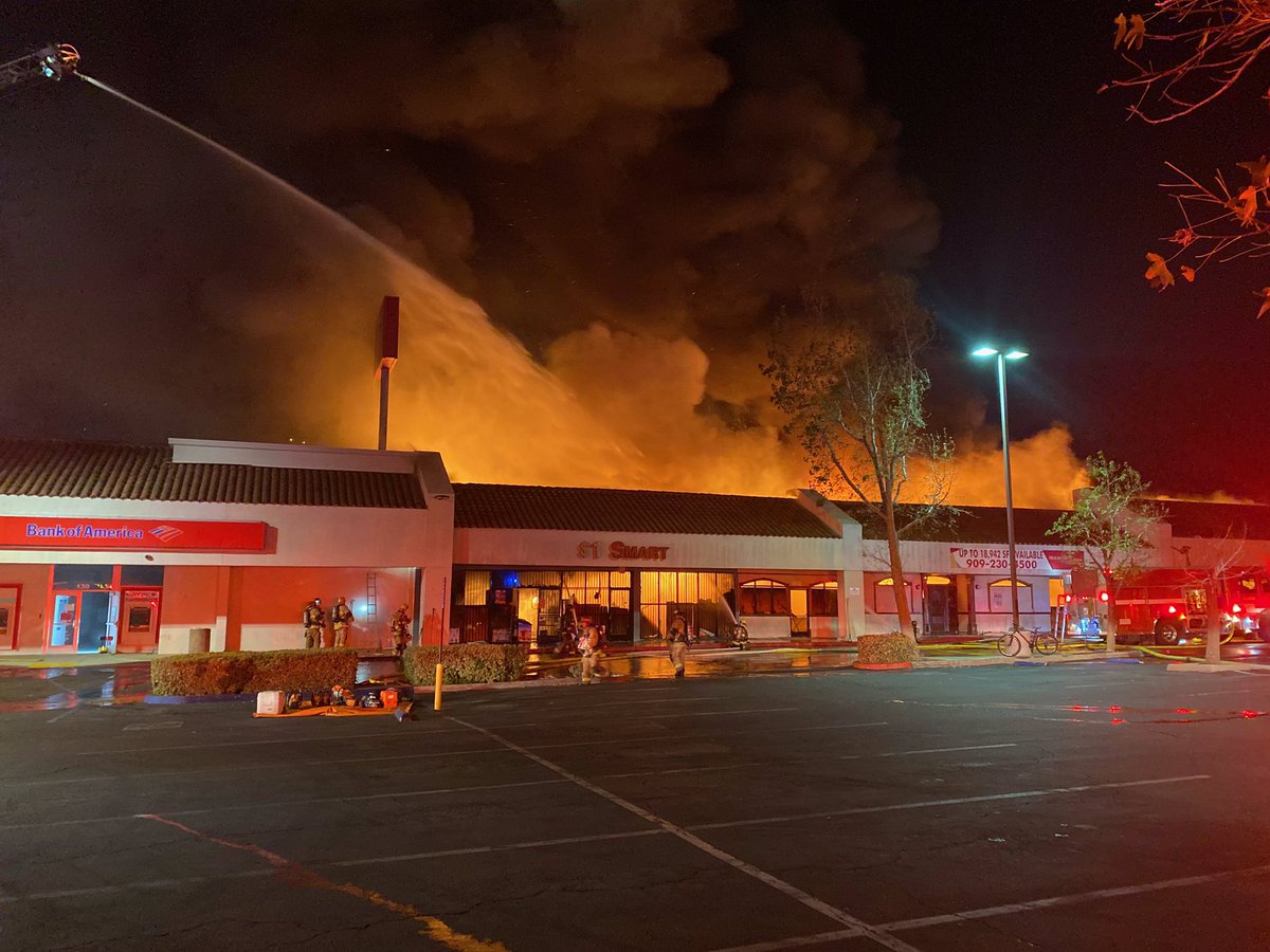 SBCOUNTYFIRE's tweet photo. San Bernardino (Update): Sierra IC requesting 3RD ALARM.  Fire extending into multiple palm trees &amp; adjacent storage buildings.  Operational retreat, switching to defensive fire attack. 4 chiefs, 12 engines, 5 trucks assigned totaling approximately 60 firefighters. https://t.co/c2QDZqqNIa