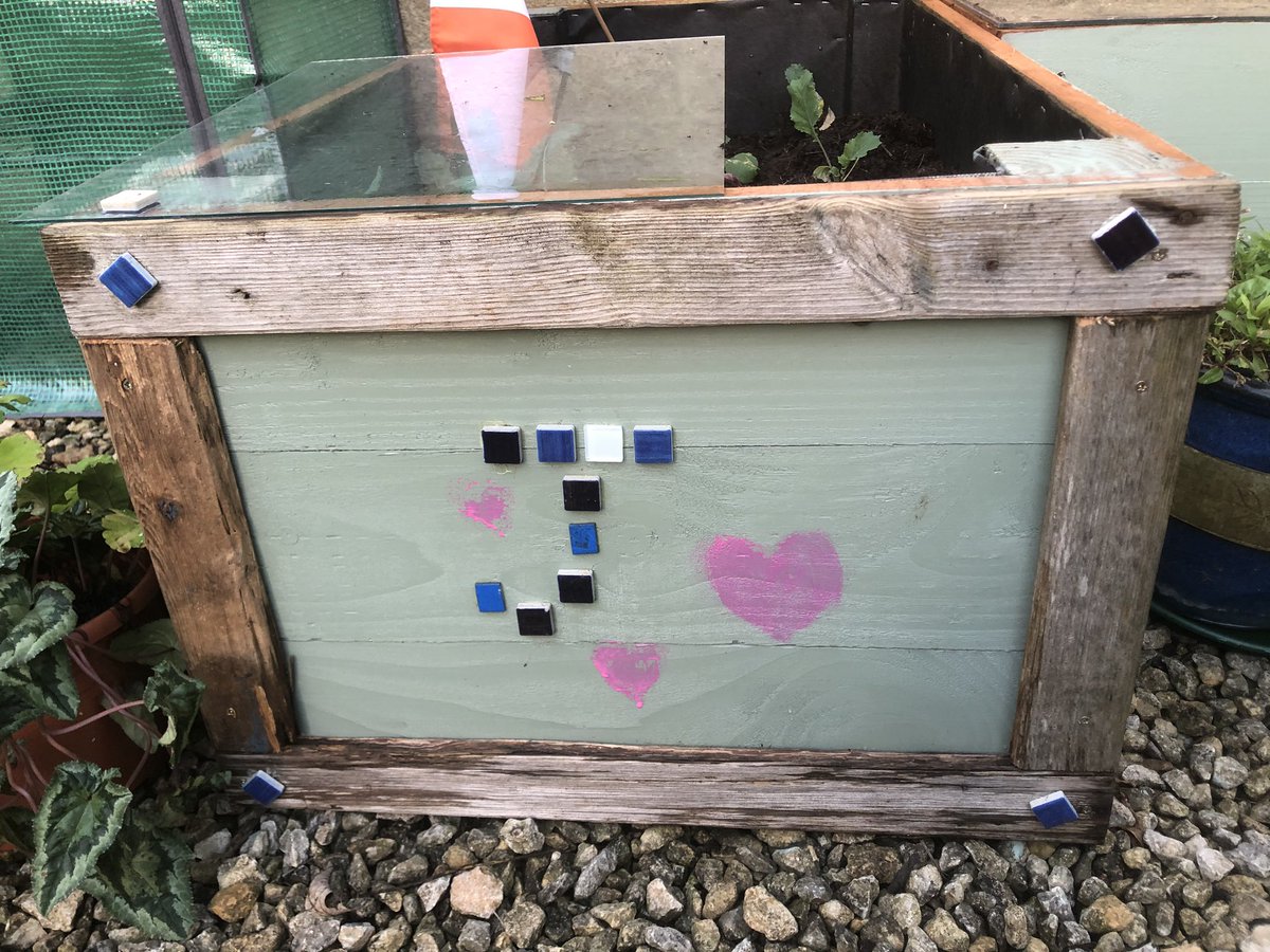AuthorPatsy's tweet photo. It s 7 years since my daughter Jasmine died and the veggie boxes she made me have fallen apart. So a friend has made new ones and we’ve cut up some of her wood and framed them on the ends. Yesterday I made her name in mosaic and then painted hearts. It looks FAB! https://t.co/pPzgAmujAf