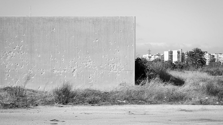 EK McConnell, Bullet holes. Wall against which executions apparently took place while the fairground was occupied by Syrian forces up to 2006. Source: Flickr. CC BY-NC-ND 2.0