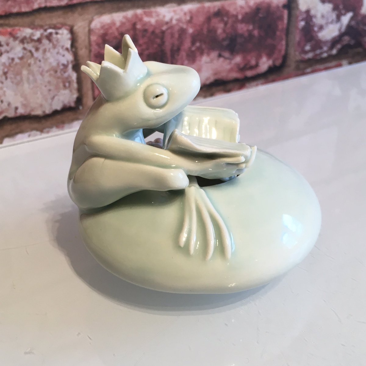 peter_swailes's tweet photo. A little porcelain frog sharing his book - the pot was thrown on my wheel and the figure and details were modelled from scratch - I don’t use any moulds - this one is 9cm across and 8.5cm tall. #book #reading #reader #literacy #storycharacter @SwailesRuth he’s £85 inc U.K. p&p https://t.co/PIyXDs8Ncu