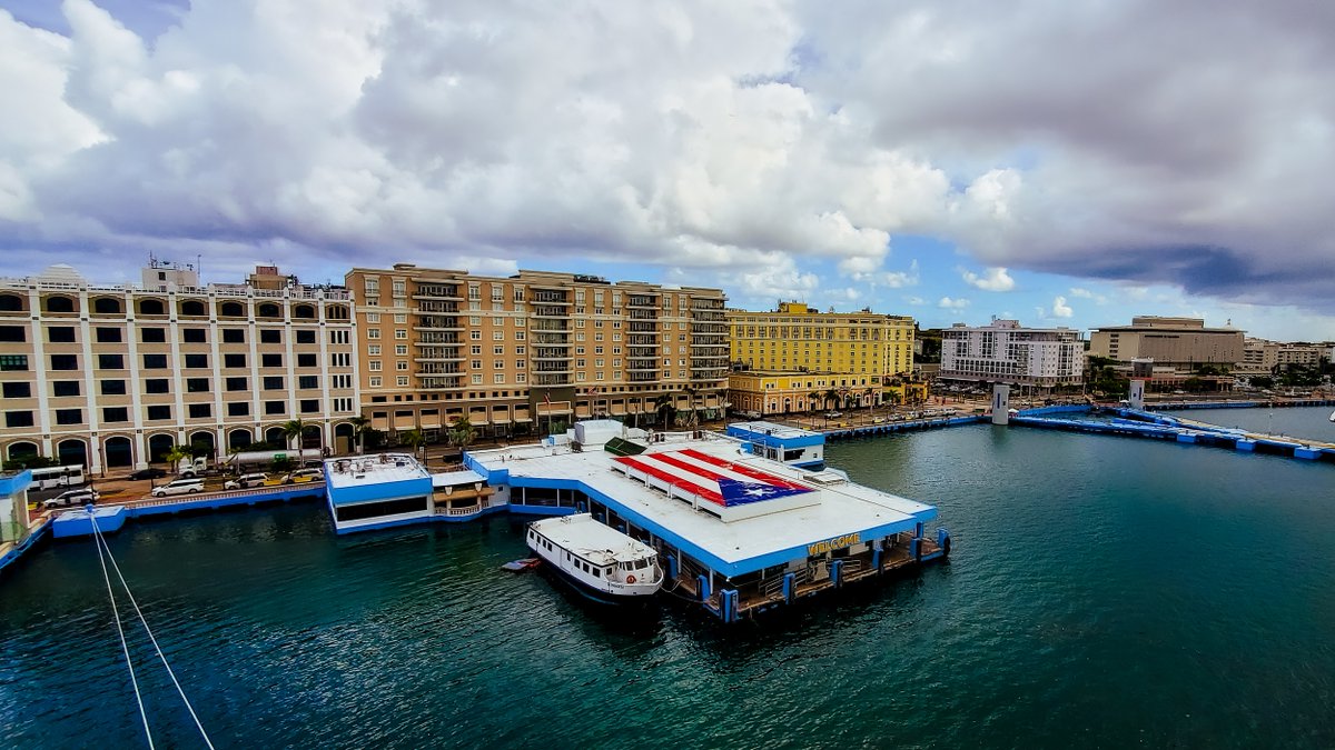 Embarky3's tweet photo. A look at the port of San Juan Puerto Rico, which welcomes us with its iconic flag, the line of buildings that tell the history of the island and the entrance to old San Juan.
 #pr #puertorico #islandvives #beautifullandscape #landscapelovers #oldsanjuan  #embarky https://t.co/jpvMoAdEp5