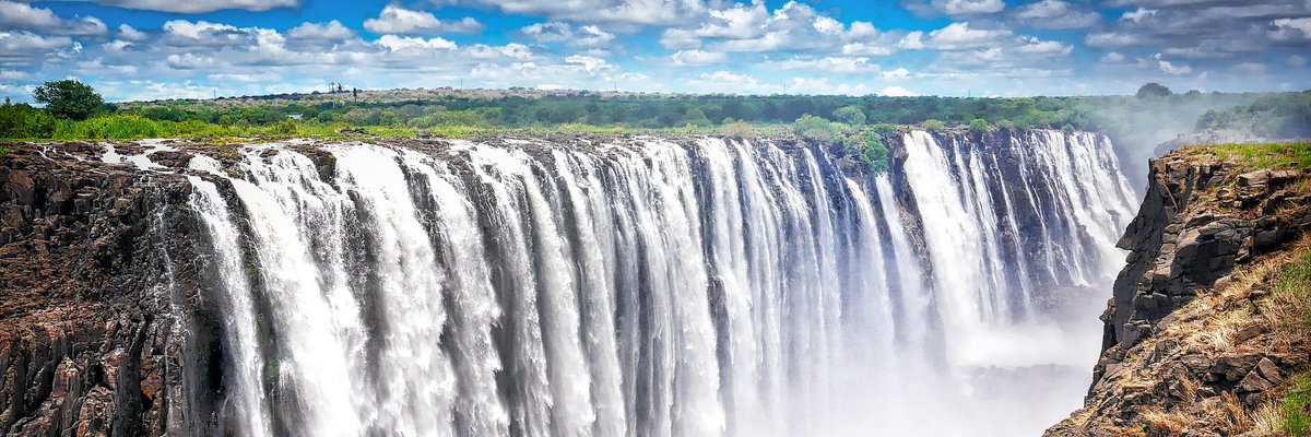 #GlobalGlances: Victoria Falls sits on the Zambezi River, the border between Zambia &amp; Zimbabwe. "Described by the Kololo tribe as ‘Mosi-oa-Tunya’ – ‘The Smoke that Thunders’...Victoria Falls is known as the greatest curtain of falling water in the world." ow.ly/3iEJ50CbljI