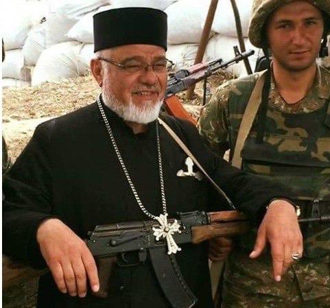 When I served in the US Army I never once saw a Chaplain carrying a weapon. Only a Bible. 

Also, imagine the outcry there would be if this was an Imam carrying an assault rifle.
