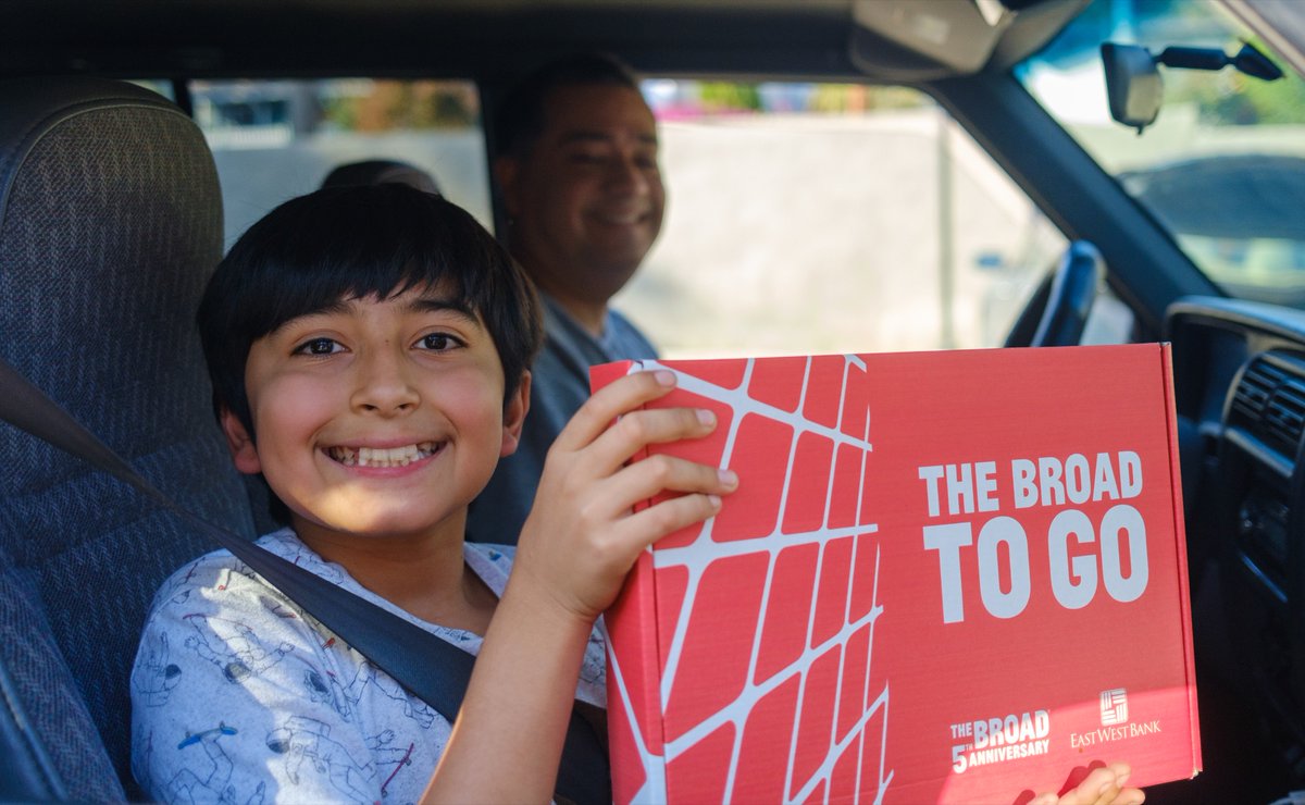 Boy smiling holding The Broad To Go art kit