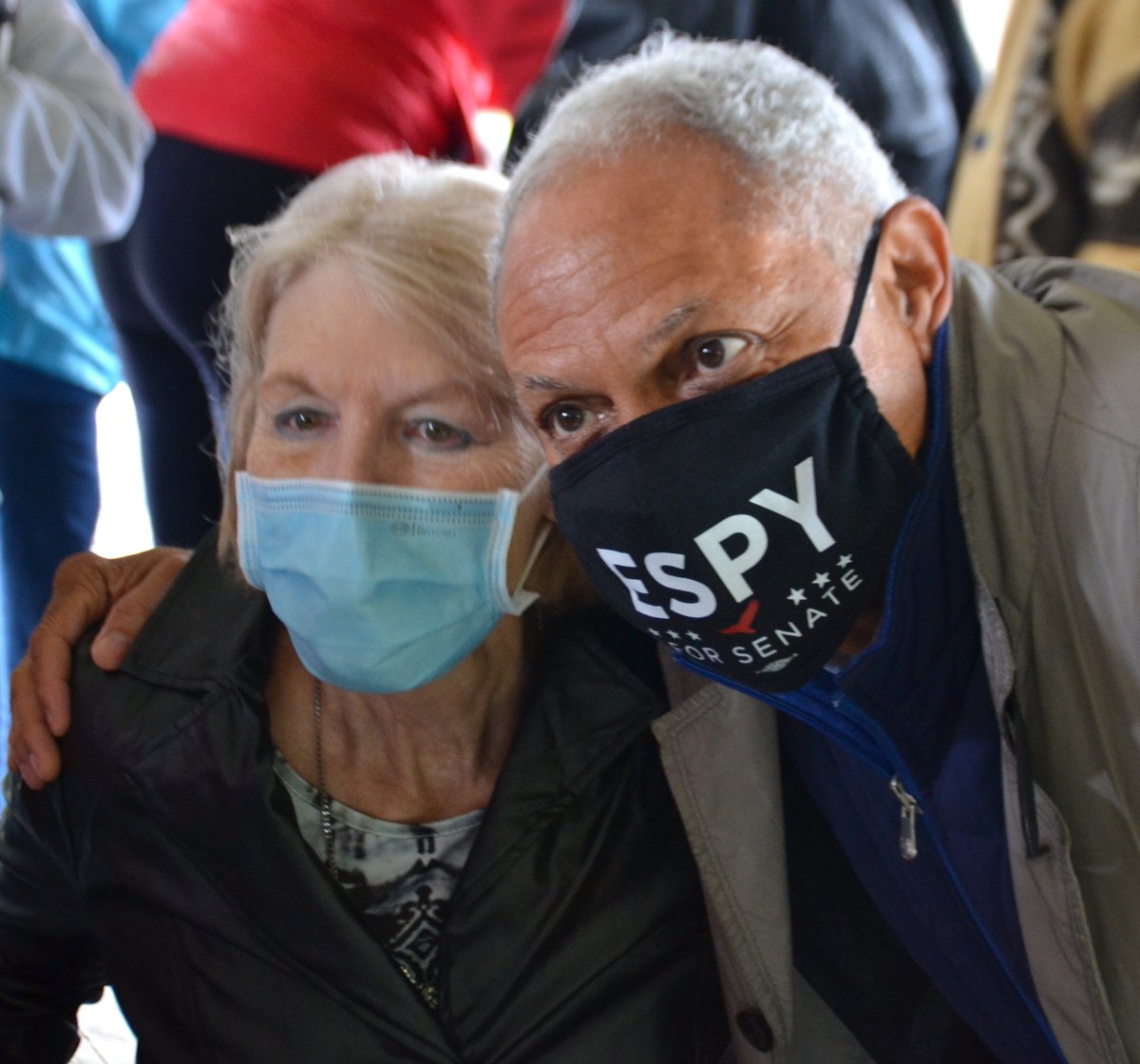 Mike Espy takes a photo with a supporter. They are both wearing a mask.