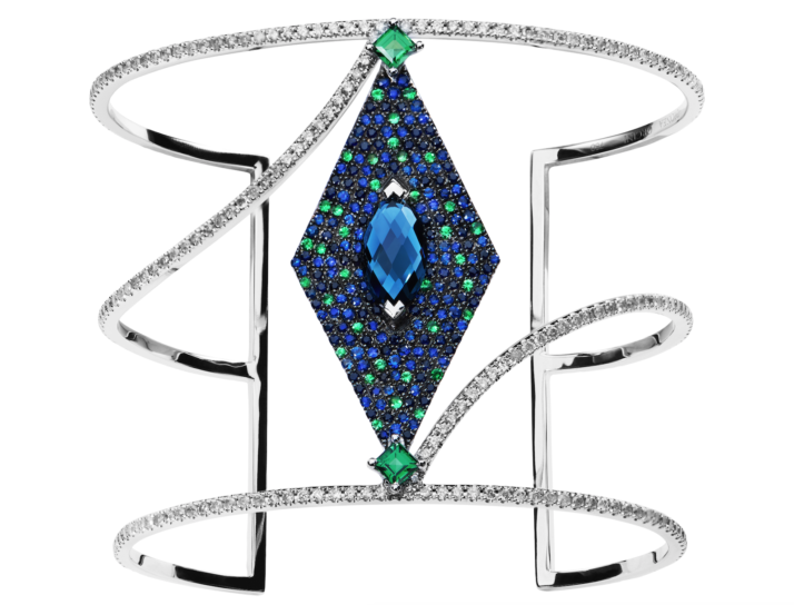 From Orcini, sapphire, blue tourmaline, and tsavorite (green garnet). Love the cut on the central stone. And the setting. And the step cuts on the garnets at the edges. And the diamond swoop.