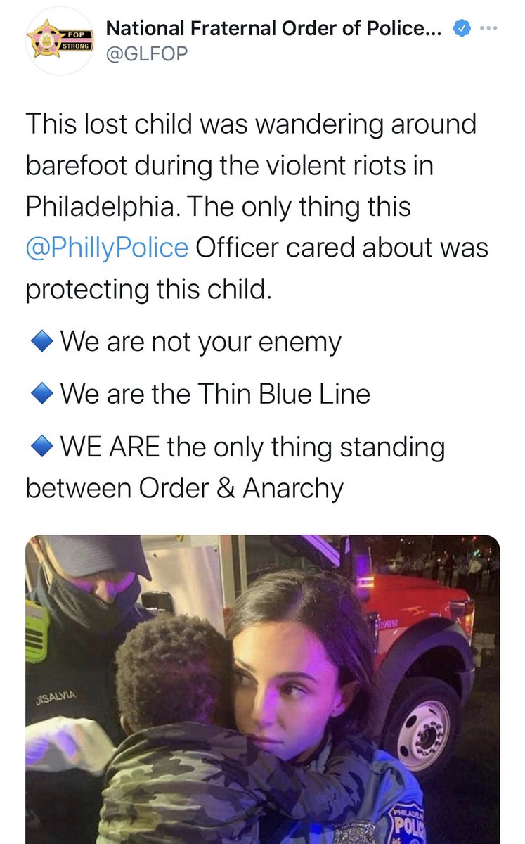 National Fraternal Order of Police @GLFOP tweets: This lost child was wandering around barefoot during the violent riots in Philadelphia. The only thing this @PhillyPolice Officer cared about was protecting this child. We are not your enemy We are the Thin Blue Line • WE ARE the only thing standing between Order & Anarchy

And attached image shows the black toddler in the arms of the white female cop who just kidnapped him.
DISALVIA, a medic, appears to be removing something (likely glass) from the child's shirt.