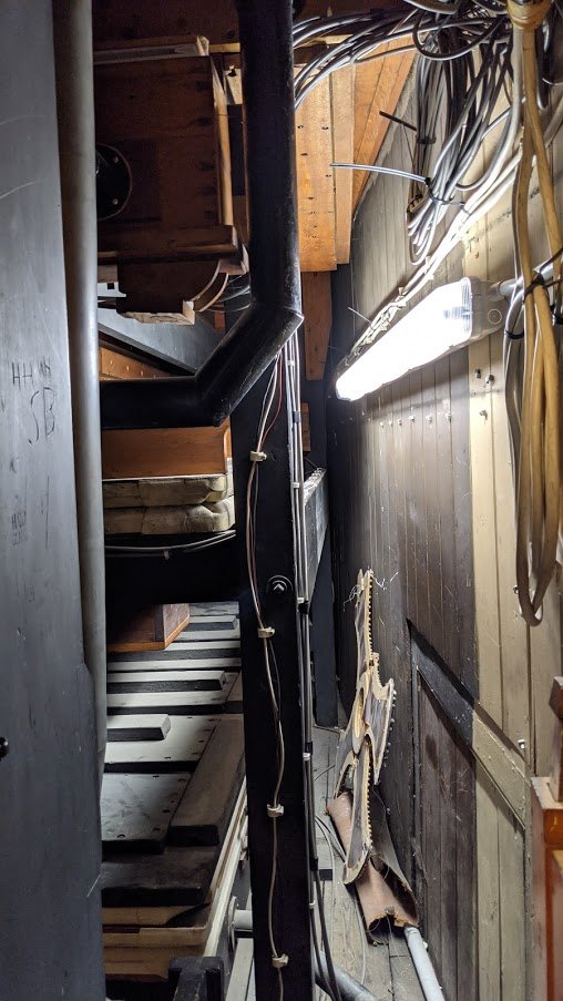 Even back there, inside the organ, amidst the dust and pipes, signs of church life floated about in scraps of paper, and props from old events.