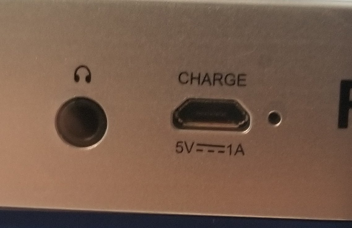 It charges using microUSB, and they helpfully told you the voltage of it, in case you accidentally use a 12v microUSB cable that shouldn't exist.